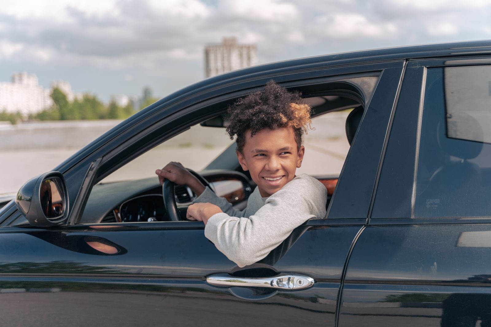 Junger Fahrschüler freut sich im Auto